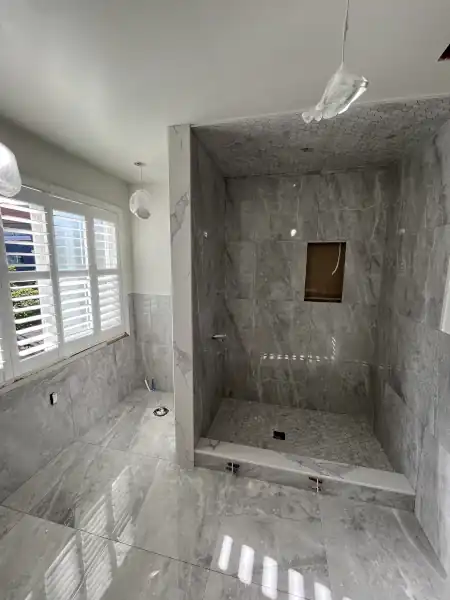 Bright finished shower with natural light and marble tile