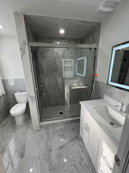 Finished bathroom with glass shower, vanity and mirror