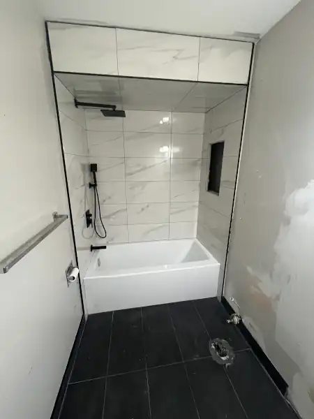 Finished tub surround with marble tile mosaic accent stripe