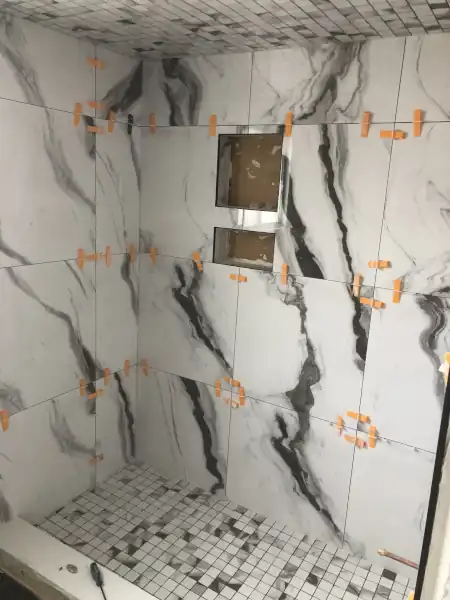 Finished tub-shower combo with marble tile surround